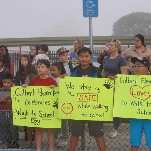 Gilbert students promote Walk to School day in front of the school.
